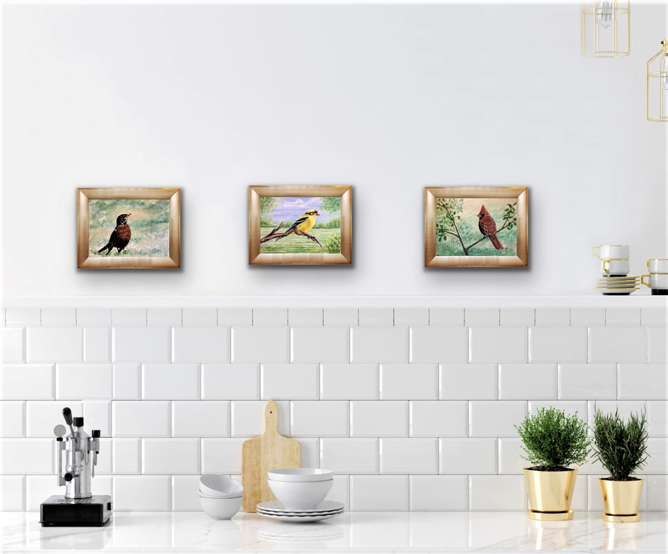 3 Pretty Songbird paintings by Susie Caron displayed above a kitchen counter.